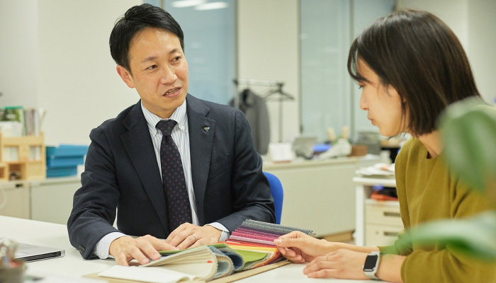 スタッフと打ち合わせる泉