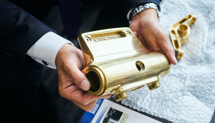 工作機械の加工ワークを手にする森田