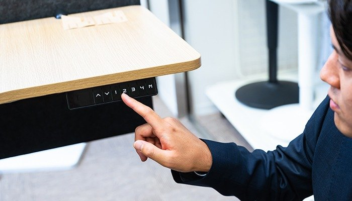 電動昇降デスクについて話す坂本