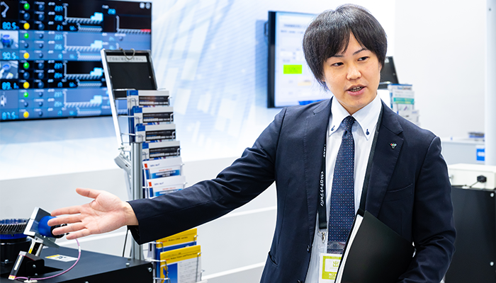 来場客に自動化ラインを説明する冨永