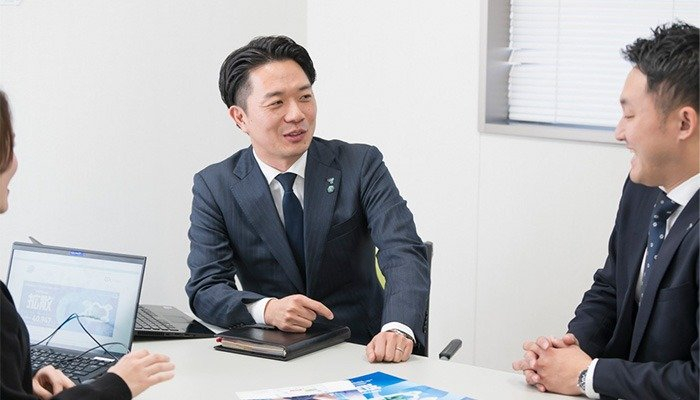 次の展示会に向け社内で情報交換をする早津