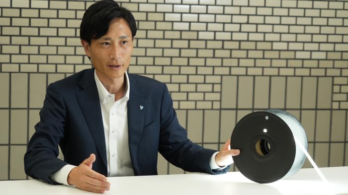 テープ型ライトを手にする白波瀬。展示会で得た現場の声を反映した商品