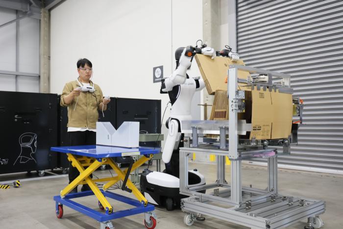 ヒューマノイドロボットが段ボールを持つ様子